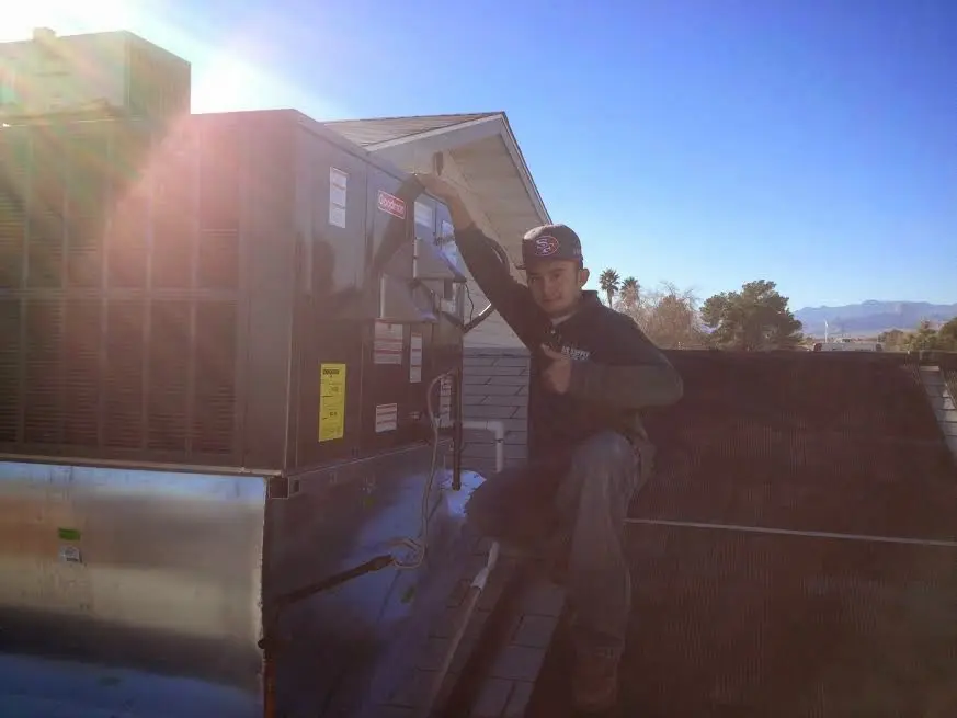HVAC technician performing Boiler Repair on a rooftop unit in Lee's Summit
